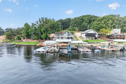 Lakefront property with private dock and boat slips, surrounded by wooded hills and peaceful water.