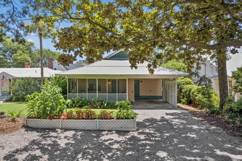 A charming vacation rental nestled in a peaceful neighborhood, surrounded by mature trees and lush greenery, with off-street parking for your convenience.