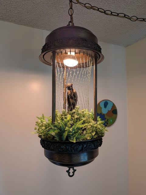 Unique vintage hanging oil light with greenery and warm, stylish charm