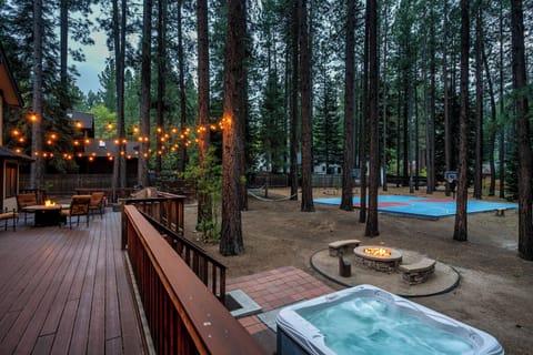 Nestled among towering pines, the backyard features a hot tub, fire pit, hammock, and basketball court—your private retreat for cozy evenings and outdoor fun.