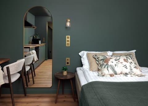 Boutique studio with cozy bed, chic kitchenette & elegant green walls