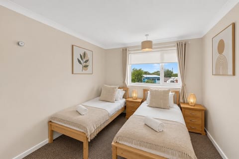 Bedroom one features a twin bed with fresh linen and towels provided.