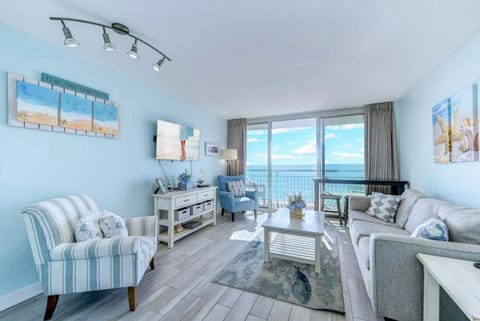 Bright living room with balcony access and comfortable seating.