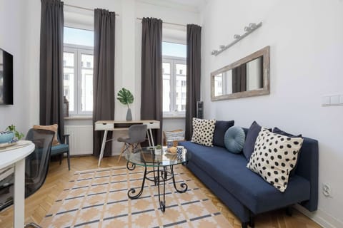 Bright living area with a comfortable sofa, dining table, and large windows.