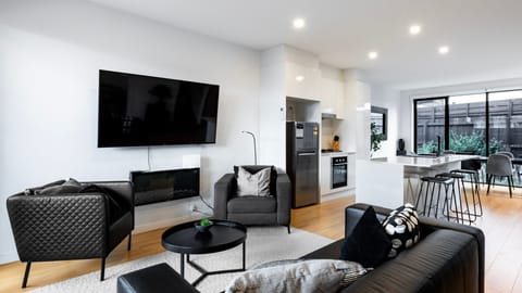 Relax in the light-filled living room with a smart TV, plush seating, and seamless indoor-outdoor flow.