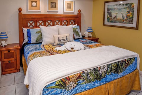 Sink into your coastal retreat with a plush bed dressed in tropical linens. Beach-themed décor and warm wood tones create the perfect escape for your sunny getaway.