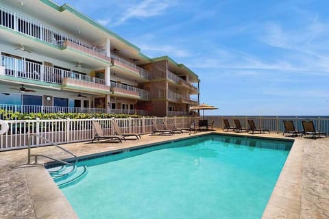 Oceanfront Swimming Pool with Lounge Chairs & Resort Exterior View