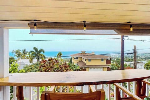 Railing frames ocean views tropical foliage and comfortable outdoor seating