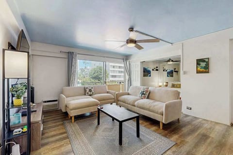 Relax in a stylish and comfortable living room featuring a ceiling fan for added airflow and comfort.