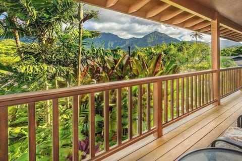 Covered balcony overlooks lush tropical foliage and dramatic mountain scenery