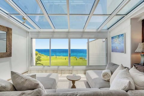Bright sunroom with panoramic ocean views—perfect for your morning coffee or a relaxing afternoon