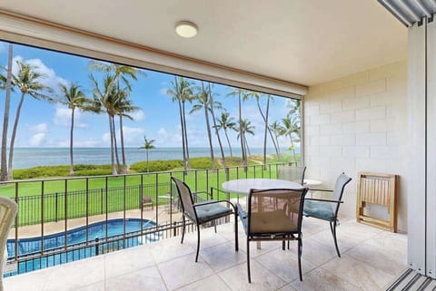 Lanai with ocean front views of the Pacific Ocean and swaying palm trees.