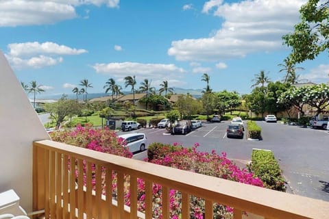 Balcony railing overlooks palm gardens parking and bright Maui skies