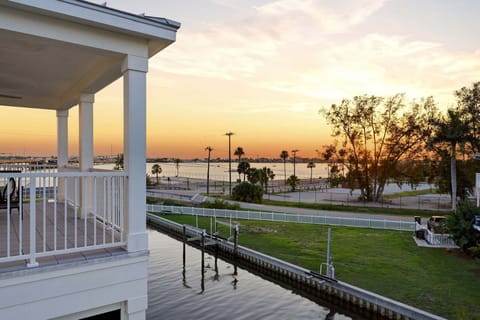An unobstructed panoramic sunset view from the rear balcony - the canal, the waterfront park green space, and the open waters of Sarasota Bay spread out beneath a sky ablaze with color, reminding you exactly why you chose this address.