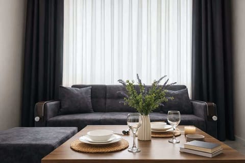 Modern lounge: chic gray sofa, set dining table, candlelit cozy vibe.