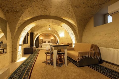 Cozy vaulted-stone suite with lounge, dining nook, and comfy bed.