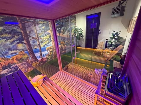 Snowghost Social features a private cedar sauna with forest mural, chromotherapy lighting, and a peaceful spa atmosphere for relaxing after adventure.