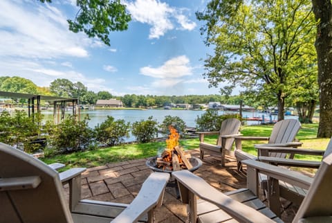 Lakeside fire pit patio with Adirondack chairs and serene water views