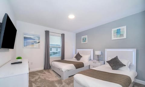 Bright double-queen bedroom with modern style and wall-mounted TV