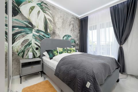 A cozy bedroom with a comfortable double bed and elegant botanical décor. The perfect place to enjoy a peaceful night's sleep.