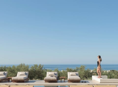 Poolside living unfolds with effortless grace, where shaded lounges, open-air ea