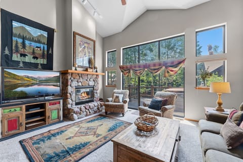 Unwind in your spacious living room where soaring ceilings and abundant natural light create an inviting mountain retreat. Cozy up by the stone fireplace or step out to your private deck surrounded by trees.