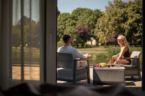Wyjątkowym atutem apartamentu jest balkon z widokiem na rzekę, wyposażony w meble wypoczynkowe. To idealne miejsce na poranną kawę, odpoczynek w ciągu dnia lub spokojny wieczór w otoczeniu zieleni.