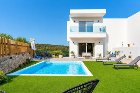 Modern villa with a private pool, sun loungers, and a peaceful landscaped garden.