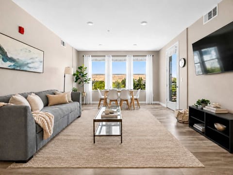 Welcome to your bright living space, thoughtfully designed for comfort and connection. Relax on the cozy sofa, stream your favorite shows on the large smart TV, or gather around the dining table bathed in natural light from the expansive windows