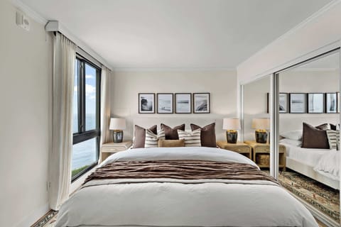 Bedroom 1 features a king size bed with 100% cotton bed linens, expansive ocean views, a full closet, and a large flat screen TV.