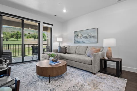 Bright living room with expansive windows overlooking the golf course.