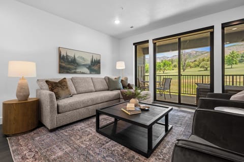 Relax in the comfortable living room with fairway and mountain views.