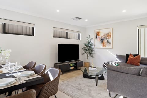 Relax or entertain in style within our open-plan hub, featuring a fully set dinner table with quilted leather seating, an ultra-comfortable charcoal sectional lounge, and a large smart TV for cozy movie nights.