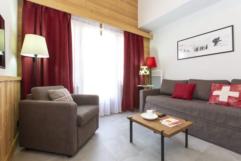 The living room's timber ceiling and wood panelling bring authentic Savoyard warmth to your evenings after a day on the Portes du Soleil.