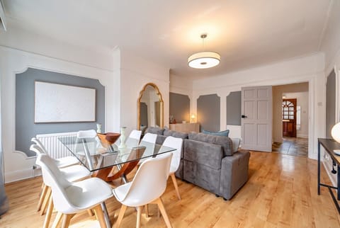 Gather six around the glass table under warm pendant light for shared meals