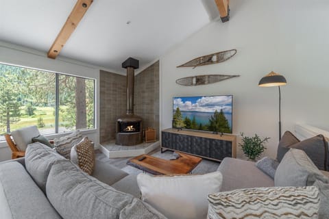 Unwind in your cozy living room with vaulted ceilings, exposed beams, and a crackling fireplace that sets the perfect mountain retreat ambiance. Sink into plush sofas and enjoy breathtaking forest views through expansive windows.
