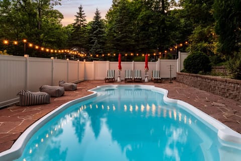Party all summer day in the private in-ground heated pool with string lights and serene wooded privacy
