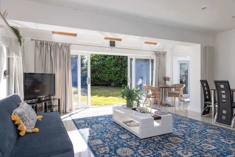 Relax in this modern holiday home living space with doors opening to the garden.