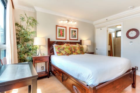 Slip into crisp linens and let tropical accents transport you to relaxation mode—your restful retreat with warm wood tones and vibrant touches awaits.