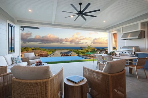 The lanai opens wide to the pool and the ocean beyond, where most days here begin and end.
