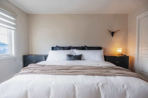 Relax in a spacious and inviting bedroom featuring a plush king bed, soft linens, and a peaceful atmosphere designed for restful nights.