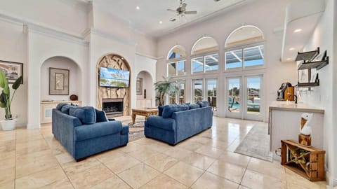 Soaring arched windows fill this open-concept living room with light, connecting seamlessly to the pool deck for easy indoor-outdoor living. The stylish, spacious layout suits families booking a waterfront vacation home near Perdido Key beaches.
