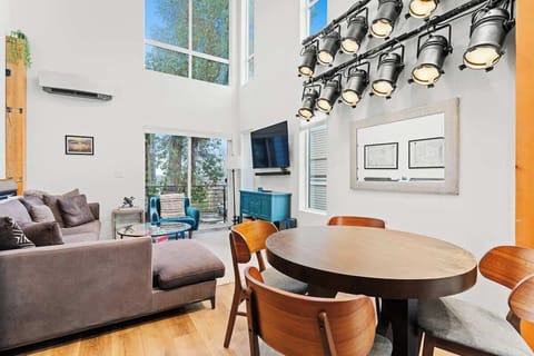 Open living space with double-height loft ceilings, exposed wood beams, and reclaimed theater lighting installation from Seattle's Moore Theater