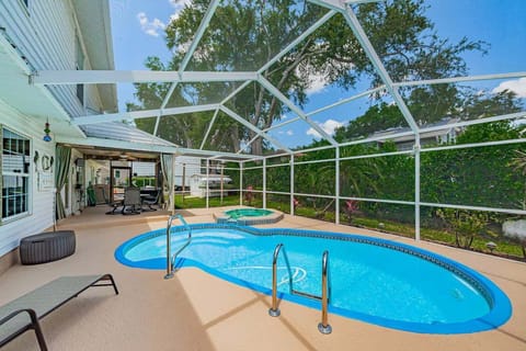 Heated pool with screened lanai and shaded lounge space