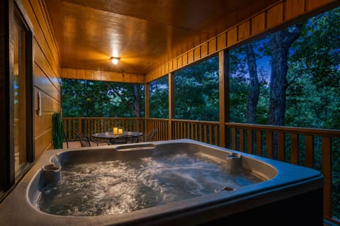 Private covered hot tub deck with serene treetop views at dusk