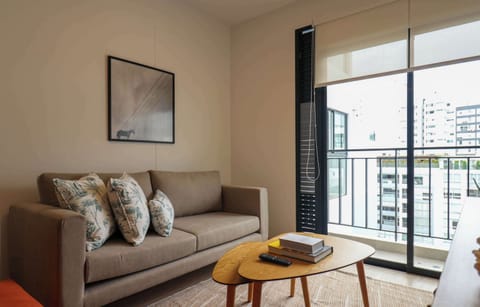 Bright living area with comfortable sofa and balcony access.