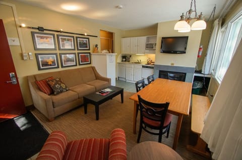 Relax on the cozy couch, framed by charming artwork that captures the essence of mountain life.
