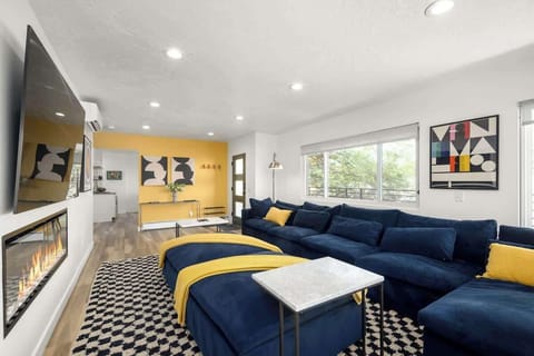 Living room with deep-seated sectional sofa, fireplace, flat-screen TV and Eames lounger and ottoman. 