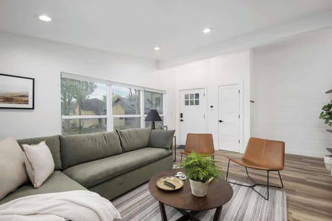 Expansive living room with sectional sofa, flat-screen TV, big windows, and cozy side chairs. 