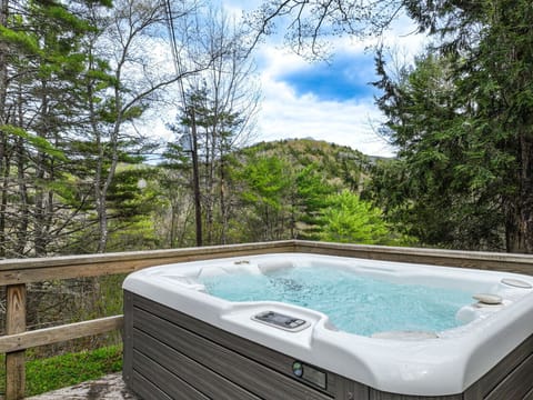 Soak your worries away in this bubbly hot tub on a wooden deck, offering the perfect spot to unwind while taking in beautiful, lush mountain and forest views.